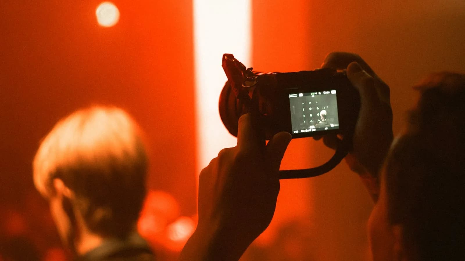 Tournage en direct : un opérateur filme un concert, cadré au plus près de la scène.